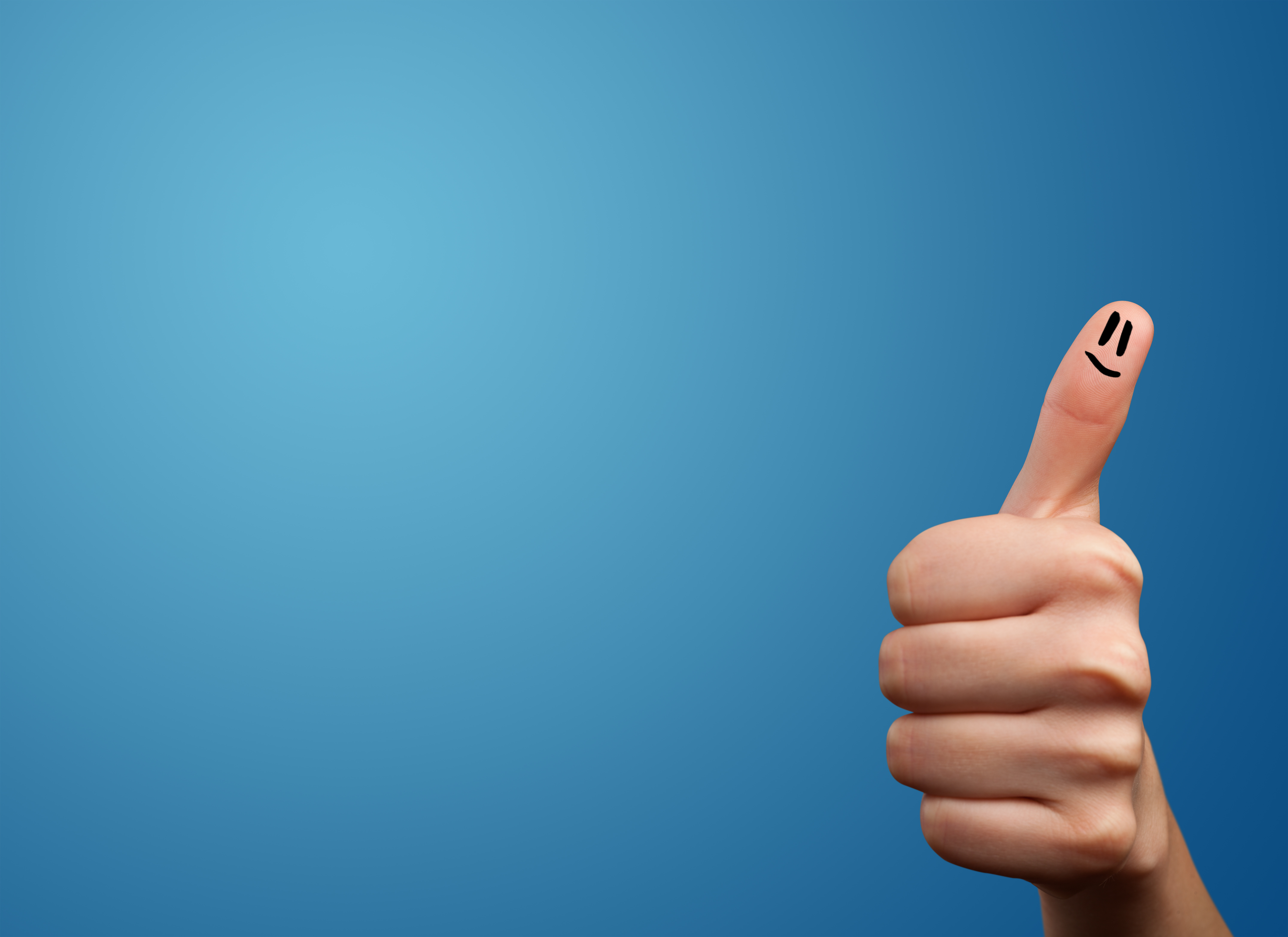 Happy smiley face fingers looking at empty blue background copy space Happy smiley face fingers looking at empty blue background copy space